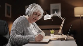 Senior woman online training. Gray-haired middle-aged woman communicates at video conference using laptop. Distance learning with online teacher