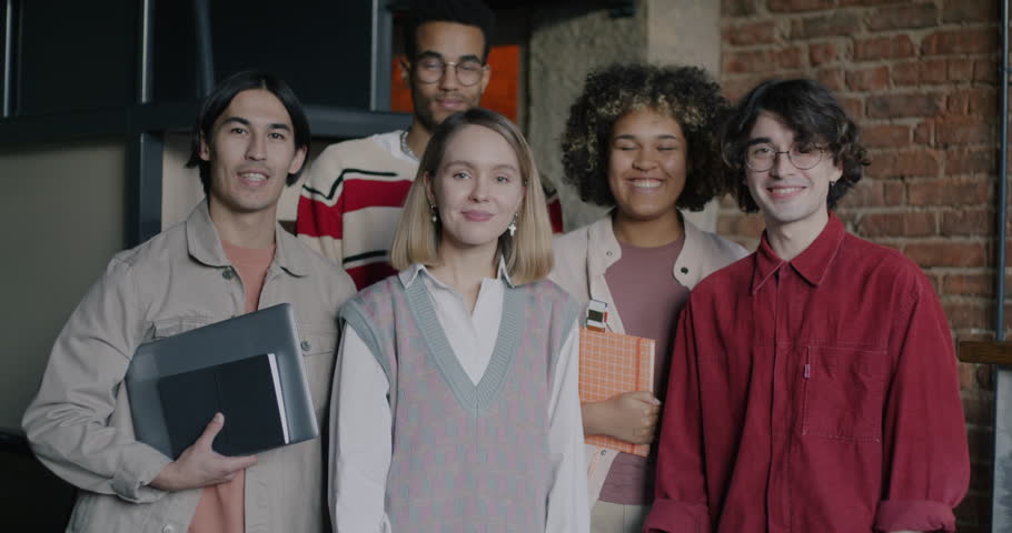 Slow motion portrait of business people diverse group standing in creative office smiling looking at camera. Successful teamwork and job concept.