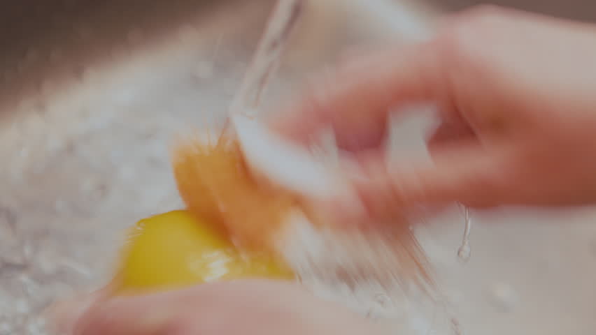 Woman fresh lemon with plastic brush, removing germs and pesticide residues from lemon skin with water. High quality 4k footage Royalty-Free Stock Footage #3487019273