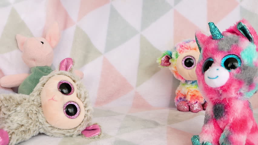 Stuffed and fluffy plush toy koala falls onto a soft baby blanket. Slow motion.