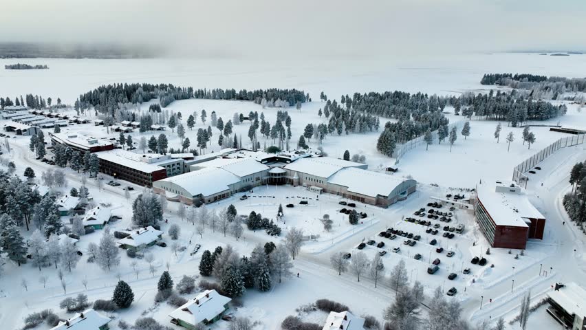Drone shot orbiting the holiday area of Katinkulta, winter sunset in Vuokatti, Finland