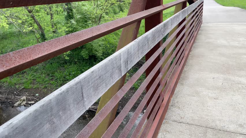 First person view of walking on pedestrian bridge on a trail in Veterans park in Lexington, Kentucky