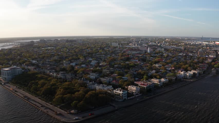 Aerial descending and panning shot of White Point Garden at Oyster Point during sunset in Charleston, South Carolina. 4K