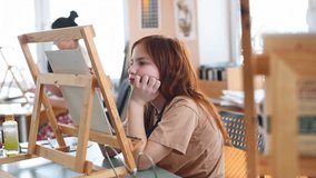 Cute sad pensive girl in art studio painting oil painting. Hobbies, Relaxation, Art Therapy - Powered by Shutterstock - Get 15% off with code: PIKWIZARD15