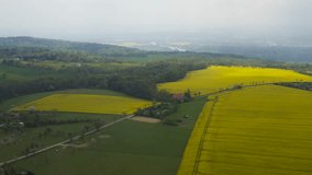 Aerial drone view  of yellow rapeseed fields in the German countryside. A river can be seen in the distance.