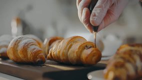 Dough. Master pastry chef pours fresh chocolate over a croissant in a production kitchen. An experienced man pours dark chocolate over baked goods and masters new recipes for baking, assorted - Powered by Shutterstock - Get 15% off with code: PIKWIZARD15