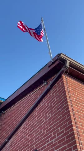 American flag waving on top of the bricked building