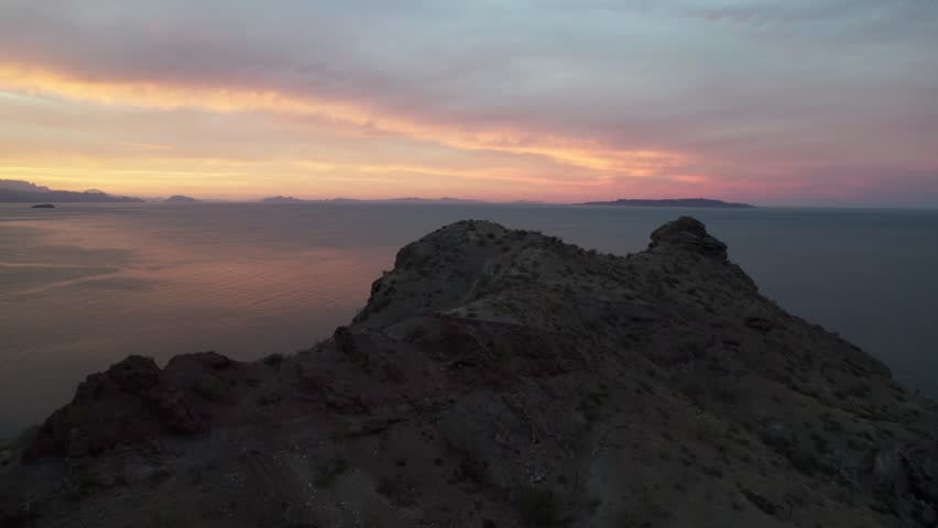 Vibrant Sky During Sunset Over The Pacific Ocean From Baja California Rocky Mountains. - aerial shot