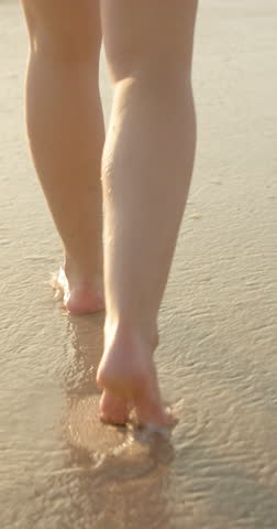 Beach, water and feet on sand with walking for summer vacation, travel and holiday on tropical island. Footprint, legs and adventure at ocean with journey for peace, calm and tourism in Mauritius