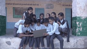 Group of Rural indian school students use laptop computer at school, Translation on wall, "Those who accept defeat never win and those who win never. Principal and wife principal " - Powered by Shutterstock - Get 15% off with code: PIKWIZARD15