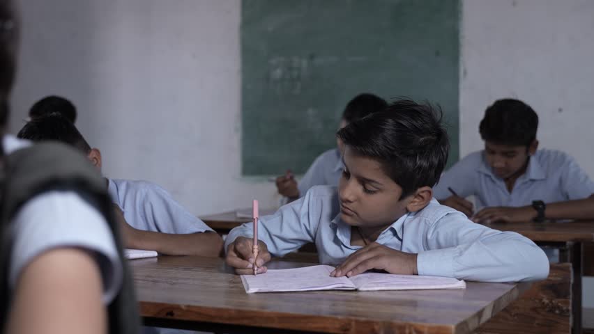 Rural Indian school students study in classroom. Elementary boys and girls writing classwork, test or exams, Education in india concept, Knowledge.  - Powered by Shutterstock - Get 15% off with code: PIKWIZARD15
