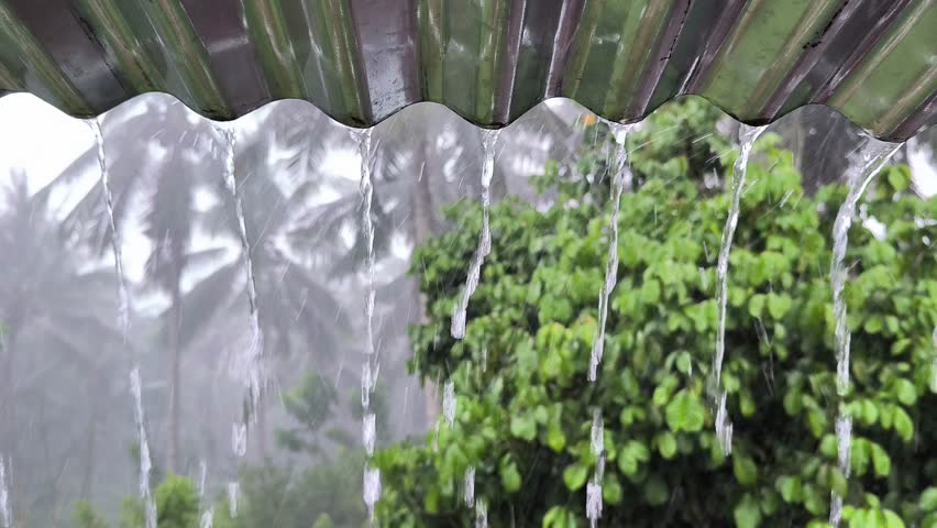 Rainwater falls from tin roofs creating a cool and peaceful atmosphere in the countryside Royalty-Free Stock Footage #3487398949