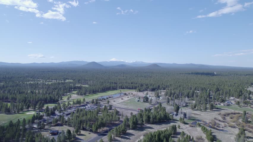 High static drone shot captures the distant Three Sisters mountains in Bend, Oregon