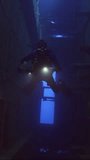 Vertical video, Scuba diver with lantern floats inside of ferry Salem Express shipwreck, Slow motion