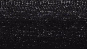 Video noise and distortion on old VHS tape. The end of an old film recorded on videotape. Black screen with artifacts and poor image flickering. Loops endlessly.