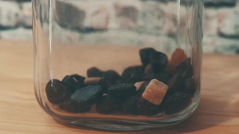 licorice candy falling into glass jar