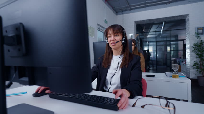 Portrait Of Woman With Headset In Call Center Or Technical Support Department Of Modern Company