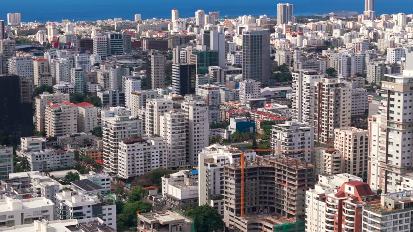 Aerial panorama of Santo Domingo downtown district. Many skyscrapers and office buildings in the city on seashore