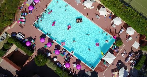 AERIAL: Swimming pool full of people having fun, view from above. 