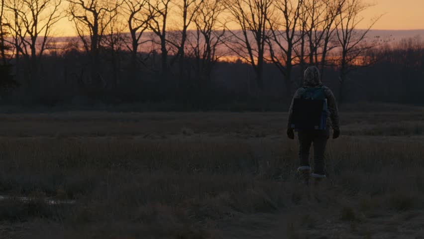 Woman Walking Through the Marsh at Sunset. Parker River National Wildlife Refuge, Massachusetts, USA. 2024