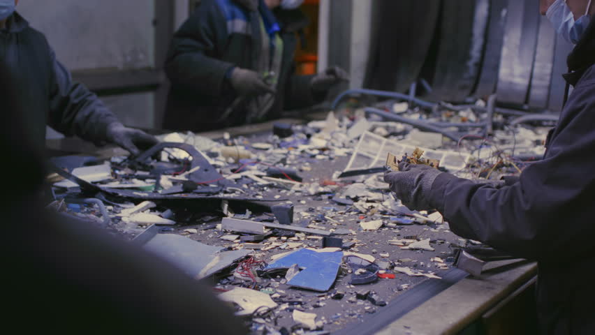 Trash sorting. Conveyor for waste. Recycling garbage. Men sort metal garbage on a conveyor. Recycle process, secondary use of plastic. Recycling factory. Male workers recycle scrap metal. Littering