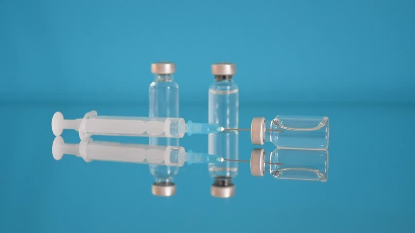 Vaccine bottles and syringe, treatment for coronavirus, influenza or flu, worldwide mass vaccination, global immunization concept. 4K resolution Royalty-Free Stock Footage #3488020277
