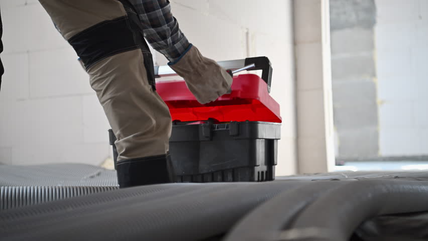 Closeup of Contractor Closing His Toolbox at Construction Site. Industrial Theme.