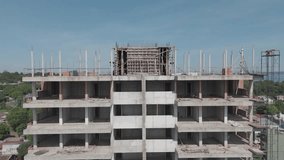 Drone footage traces the progress of a building under construction, view from the top floors to the bustling activity at ground level, capturing every detail of the evolving structure.