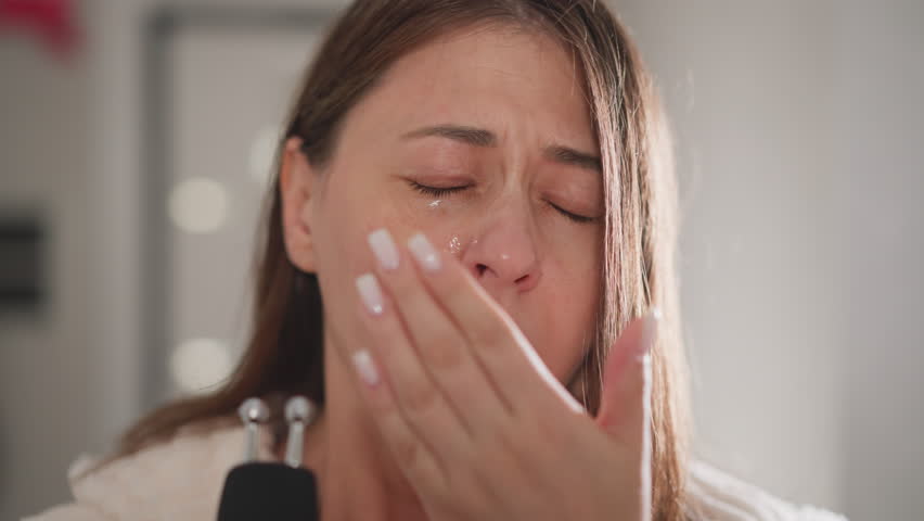 Woman feels allergic reaction after cosmetic procedure. Lady feels nasal congestion sneezing after procedure with microcurrent device in bathroom Royalty-Free Stock Footage #3488205705