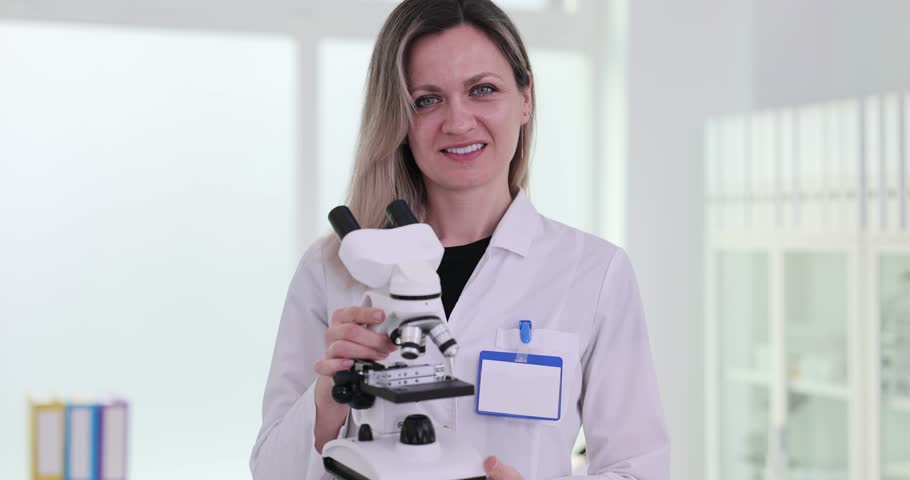 Microscopy is a tool for scientific discovery for research. Scientist biologist laboratory assistant holding a microscope Royalty-Free Stock Footage #3488213281
