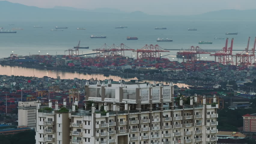 Fly around top of apartment high rise building with rooftop terrace. Torre de Manila and harbor in background. Manila, Philippines