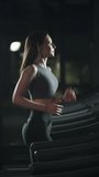 Wellness, sporty woman run on a treadmill, aerobic exercise and endurance training in the gym, nightlife, vertical video.