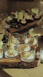 A wooden table displaying a variety of food and drinks, showcasing culinary art. Before wedding. Vertical video
