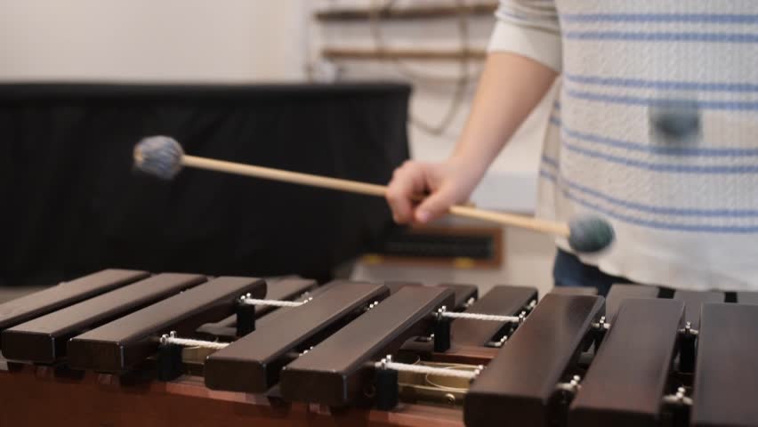 marimba instrument played by young female, fron slow motion cloesup