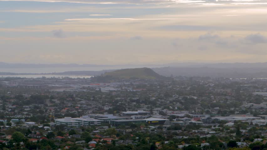 Panoramic view of Auckland, crepuscular rays through misty clouds above New Zealand
