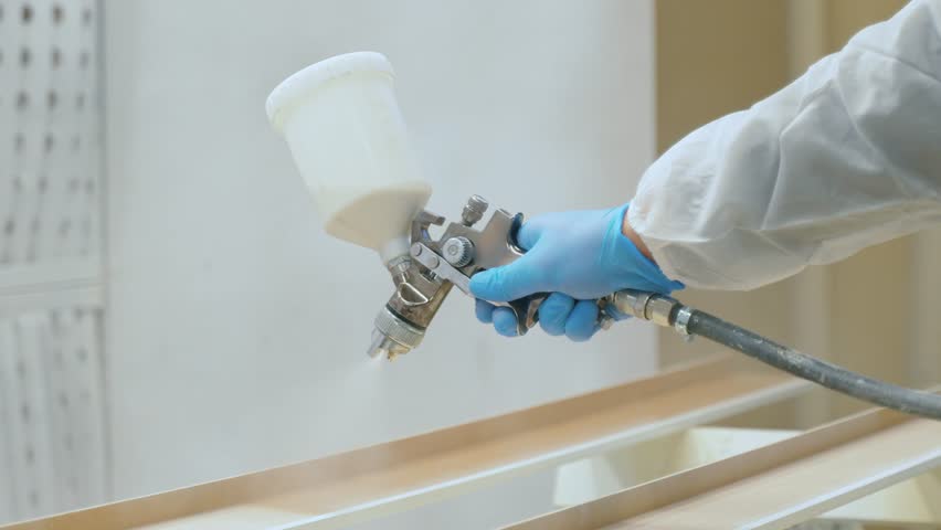 worker using spray gun and painting wood. Application of flame retardant ensuring fire protection, airless spraying. High quality 4k footage