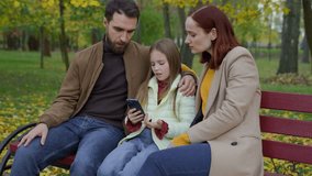 Caucasian family at city bench together outdoors autumn sad upset confused worried with mobile phone bad news smartphone failure little daughter girl child kid with parents mother woman father man - Powered by Shutterstock - Get 15% off with code: PIKWIZARD15
