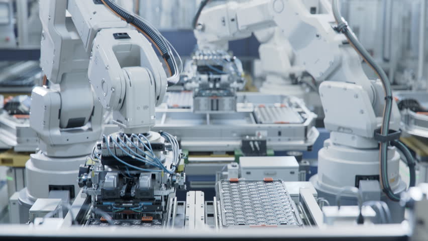Automated Production Line with White Robotic Arms at Bright Factory. Robot Arms Assemble Lithium-Ion EV Battery Pack for Automotive Industry. Electric Car Smart Manufacturing Line