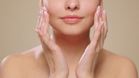 Beautiful Young Woman Touches Her Perfect Face. Natural Cosmetic Skincare Products. Woman demonstrate moisturizing facial care. Elevating Close-up Portrait with Isolated Background. Slow motion - Powered by Shutterstock - Get 15% off with code: PIKWIZARD15