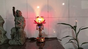 Horizontal video of silhouettes of Buddhist Gods statue. A red candle lights up in Chinese temple. Radiant red candles illuminate the ambiance of the temple Chinese New Year. Culture of faith. Praying