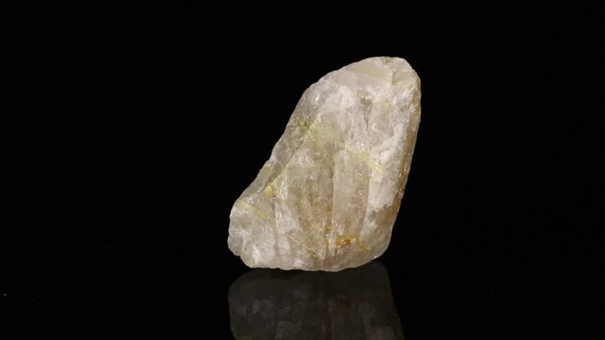 Polished mineral stone Rutile in quartz in zoisite rotates in a circle on a black background close-up