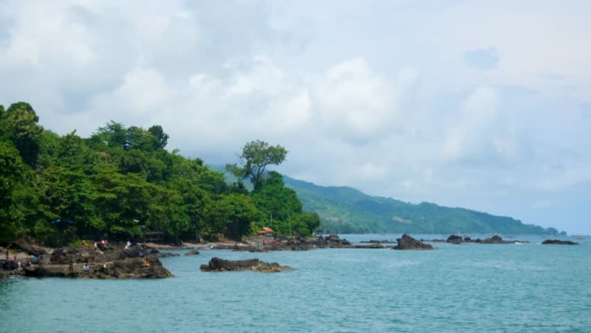 view of the coastline with coral and hills in Indonesia.