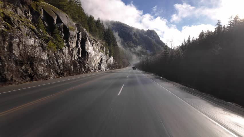 Scenic Road on a Sunny Day. Blue Sky, Clouds and Trees. Sea to Sky Highway near Squamish, British Columbia, Canada.