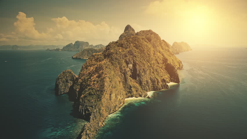Sunset at tropical island at blue ocean bay. Sun shine aerial view. Nobody wild nature scenery at amazing tropic mountains islet of Palawan, El Nido, Philippines archipelago. Cinematic summer vacation Royalty-Free Stock Footage #3488714219