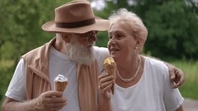 An elderly married couple in love eats ice cream in waffle cones and laughs, while walking through a city park outdoors on a sunny summer day. Happy old age of active seniors. - Powered by Shutterstock - Get 15% off with code: PIKWIZARD15