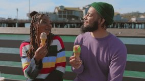 Young loving couple sitting on a wooden bench on a beautiful pier in Santa Barbara with awesome views of ocean, mountains, beach with palm trees and buildings on sunny day. High quality 4k footage - Powered by Shutterstock - Get 15% off with code: PIKWIZARD15