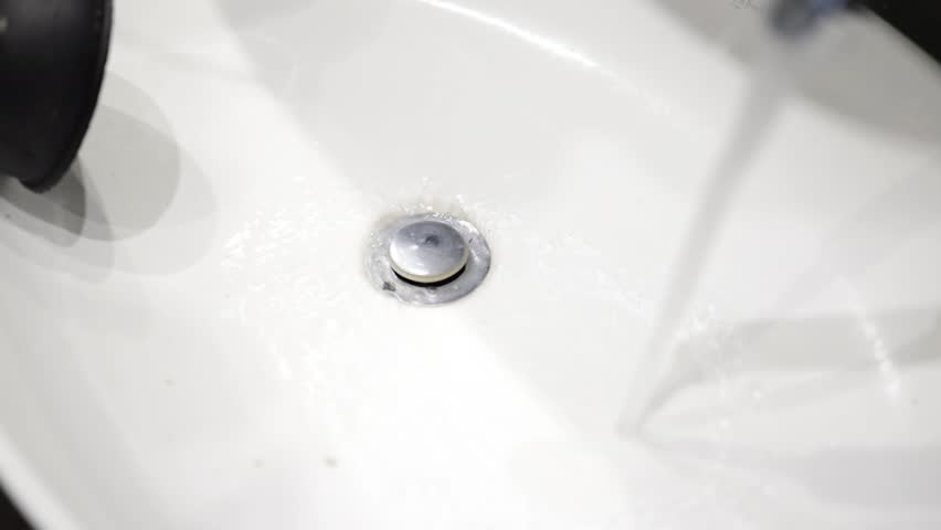 plunger unblocking white wash hand basin sink, cleaning of blockages in the sink. Royalty-Free Stock Footage #3489095479