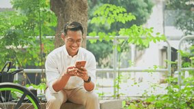 Millennial businessman sitting on bench near his bicycle and checking social media on mobile phone - Powered by Shutterstock - Get 15% off with code: PIKWIZARD15