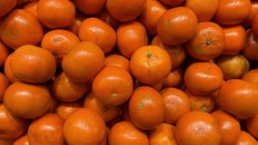 A box of fresh organic tangerines for sale in a greengrocer's store. High quality 4K footage