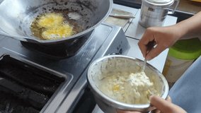 The process of frying corn bakwan on a frying pan with hot cooking oil, cooking process, stock video.